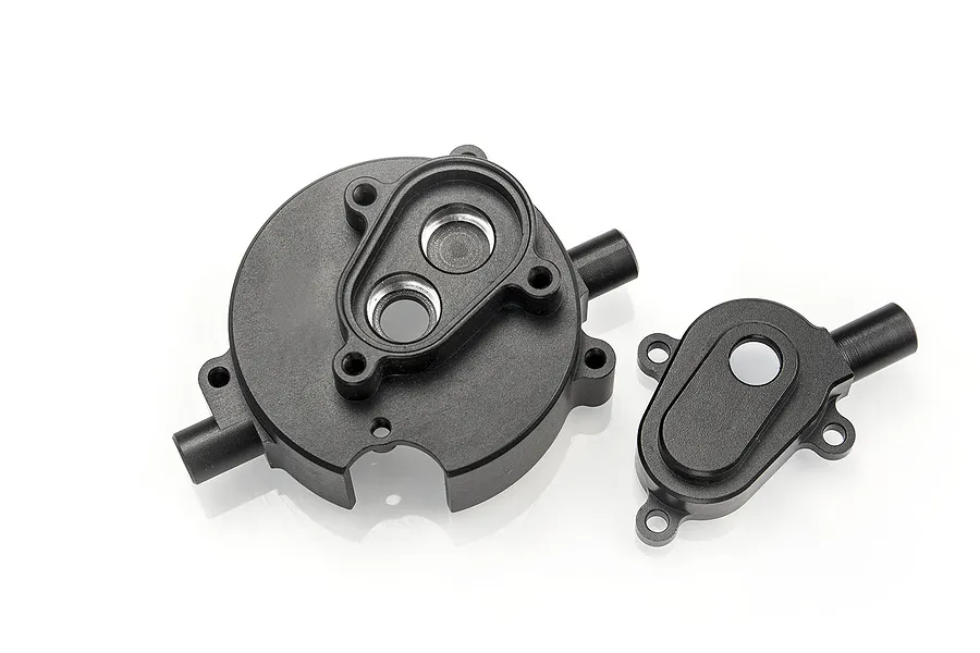 Two black aluminium transmission gear housing components for an RC car, shown on a white background.