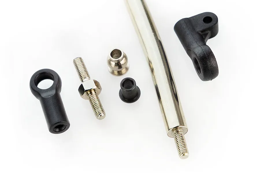 A set of disassembled RC steering linkage components including a metal rod, threaded studs, ball joints, and plastic rod ends on a white background.
