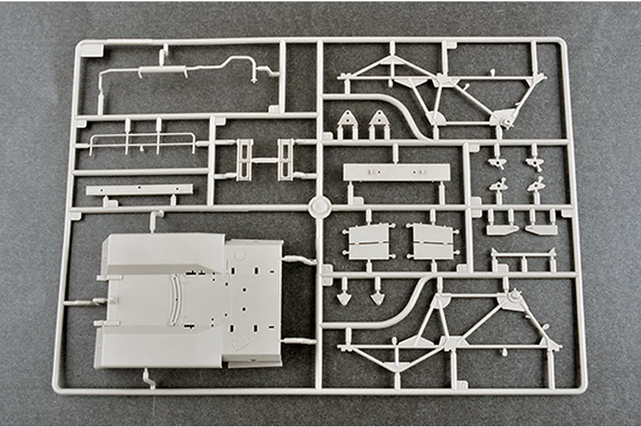 A grey plastic model kit sprue containing various parts for a 1/35 scale military vehicle, including chassis and frame components.
