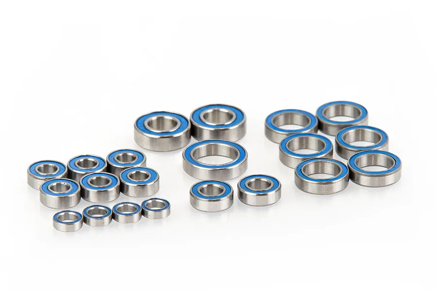 A collection of various sized metal ball bearings with blue rubber seals arranged on a white background.