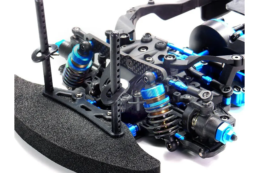 Close-up of the front suspension and foam bumper assembly of a Tamiya TB-05R RC touring car kit.