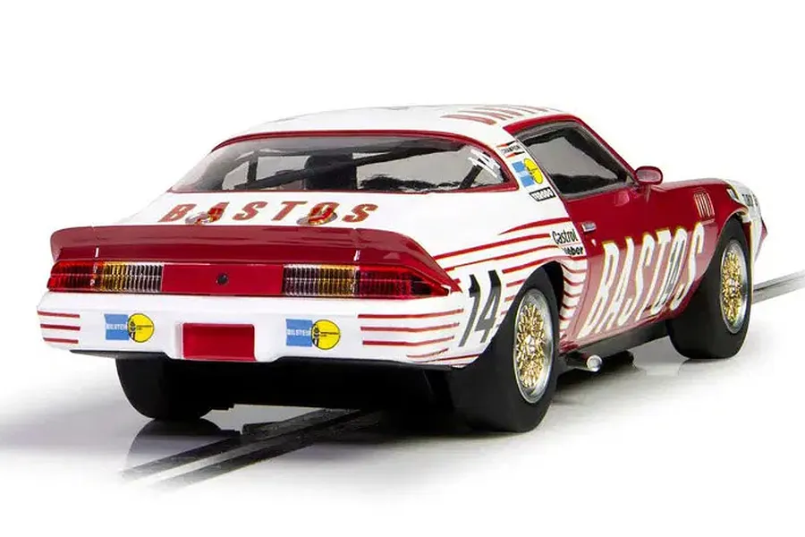 Rear three-quarter view of a Scalextric 1/32 scale Chevrolet Camaro Z28 slot car in red and white Bastos racing livery on a track.