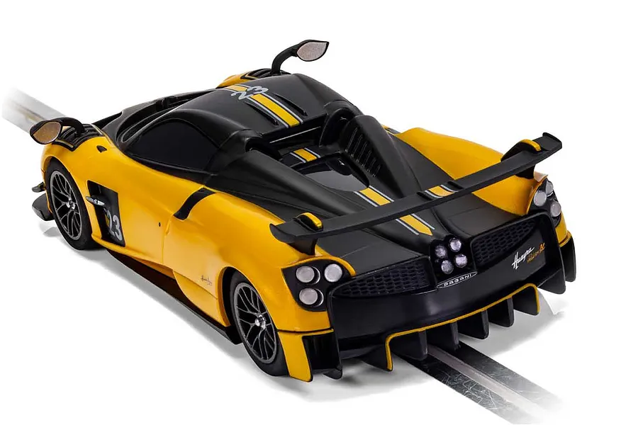 A high-angle rear view of a yellow and black Scalextric Pagani Huayra BC Roadster slot car on a track.