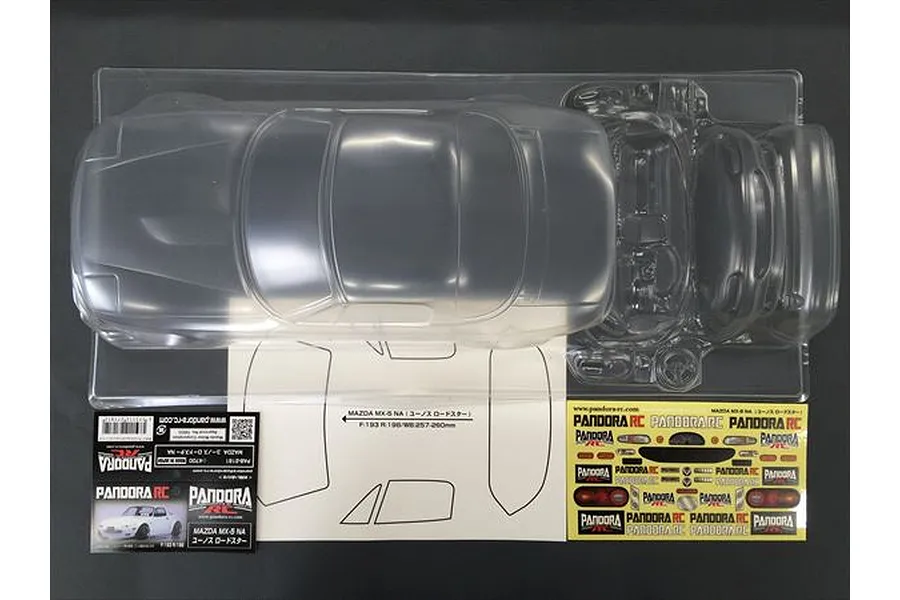 An unpainted clear polycarbonate RC car body shell for a Mazda Eunos Roadster NA, including decal sheets and window masks in a plastic tray.