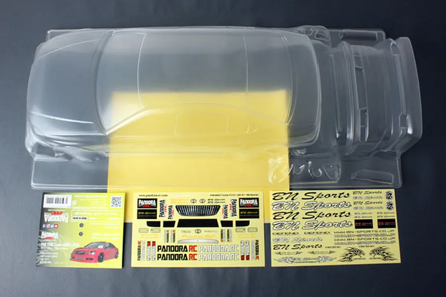 Unpainted clear polycarbonate RC car body shell for a Toyota Aristo JZS161 with included decal sheets and instruction card.
