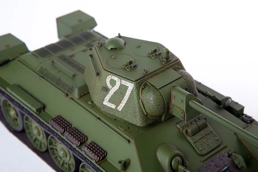 High-angle close-up of a 1/35 scale plastic model of a Soviet T-34/76 tank painted in olive green with the number 27 on the turret.