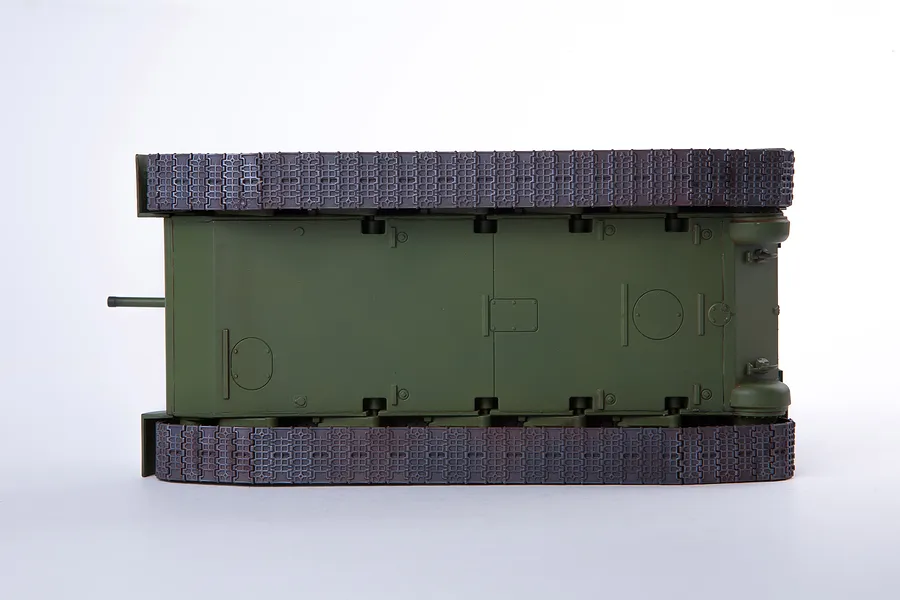 Bottom view of an assembled olive green plastic model tank showing the tracks and hull underside.