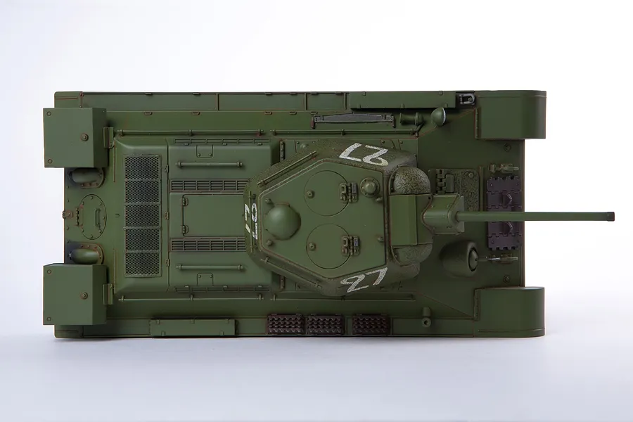 Top-down view of an assembled and painted 1/35 scale Academy T-34/76 tank model, featuring olive green paint and white number 27 markings on the turret.