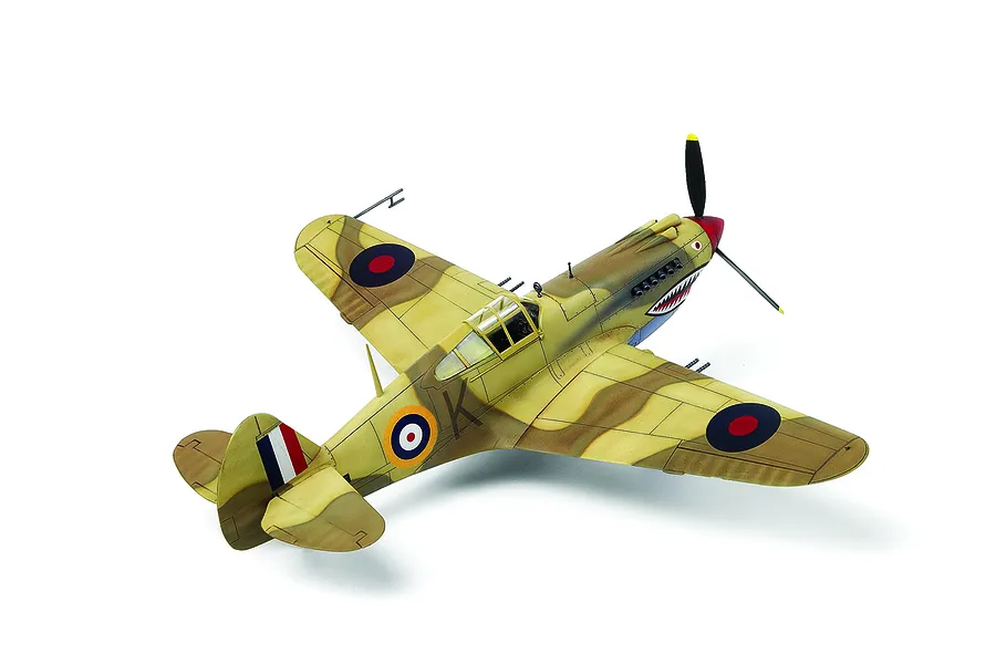 A completed 1/48 scale plastic model of a Tomahawk IIb fighter plane with desert camouflage and shark mouth nose art, viewed from above.