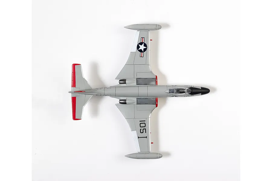Top-down view of an assembled 1/72 scale Academy F2H-3 Banshee model aircraft painted in grey with red tail accents and US Navy markings.