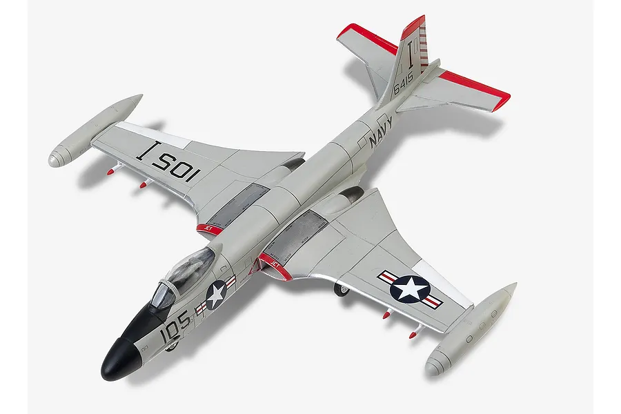 A high-angle view of a completed 1/72 scale plastic model of a US Navy F2H-3 Banshee fighter jet, painted in grey with red accents and US Navy markings.