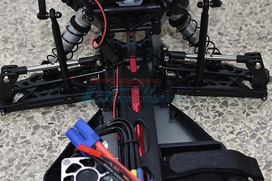 Close-up of GPM stainless steel adjustable linkages installed on an RC vehicle chassis, showing suspension components and wiring.