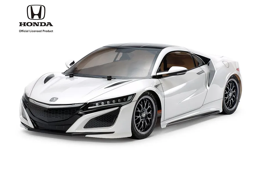 A studio shot of a white Tamiya Honda NSX RC car model on a white background, featuring black wheels and detailed bodywork.