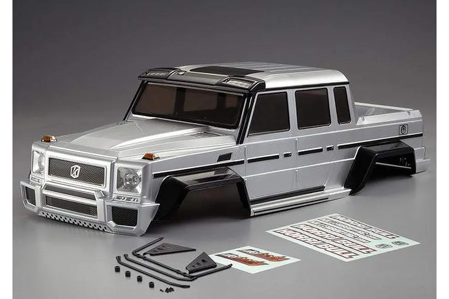 A silver painted Killerbody Horri-Bull 1/10 scale RC crawler body shell with black fender flares and included decal sheets and accessories.