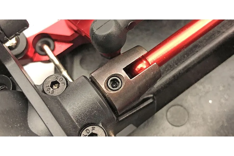 Close-up of a metal centre drive cup installed on an RC car chassis with a red driveshaft and grub screw visible.