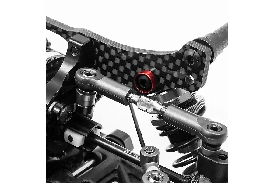 A close-up of an RC car suspension assembly featuring a red anodized aluminium countersunk washer installed on a carbon fibre shock tower.