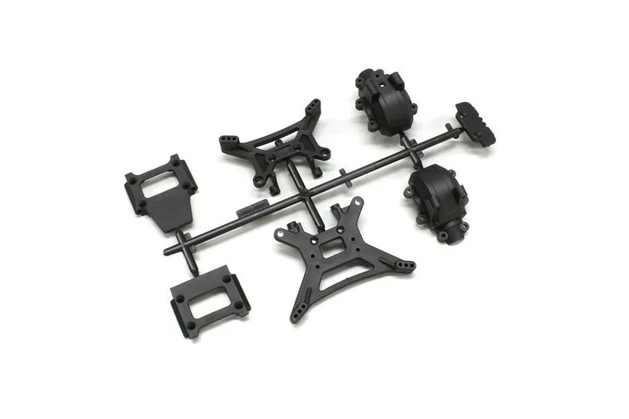 A black plastic parts tree containing shock towers and gearbox components for a Kyosho RC model.