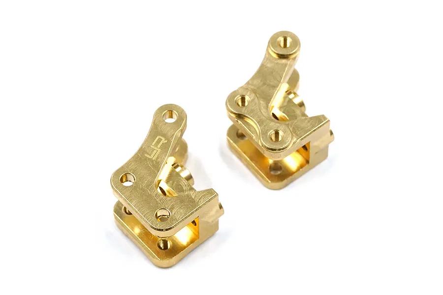 Two Yeah Racing brass front suspension link mounts for the RBX10 Ryft RC crawler, shown from an angled perspective.
