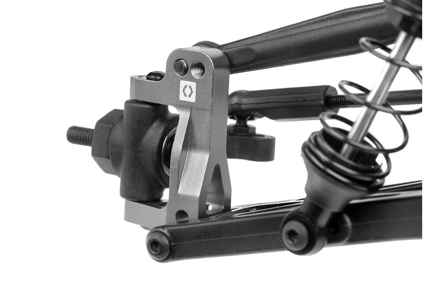 Close-up of a grey aluminium C-hub installed on an RC car suspension assembly with black plastic arms and a shock absorber.
