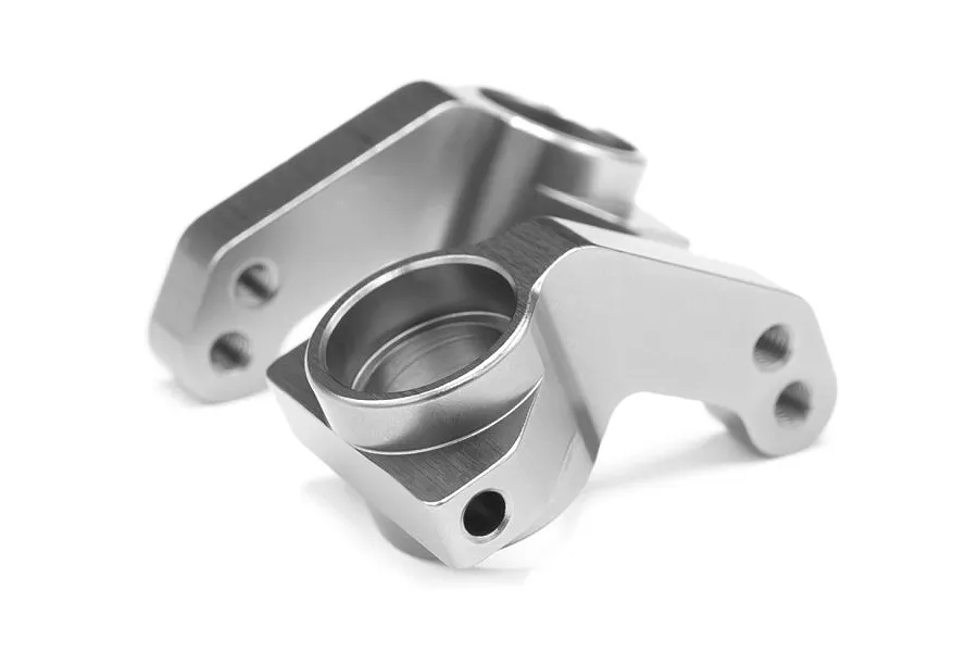 Two grey aluminium steering hubs for an RC car, shown from a high angle against a white background.