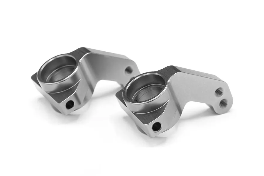 Two grey aluminium steering hubs for an RC car, shown from a high angle on a white background.