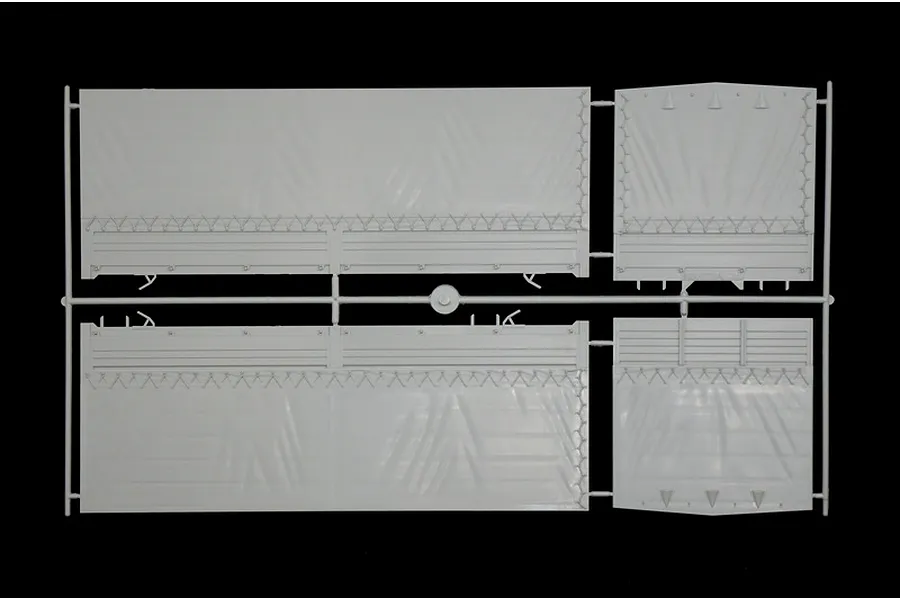A grey plastic sprue containing side and end panels for a model truck trailer, featuring molded canvas texture and side board details.