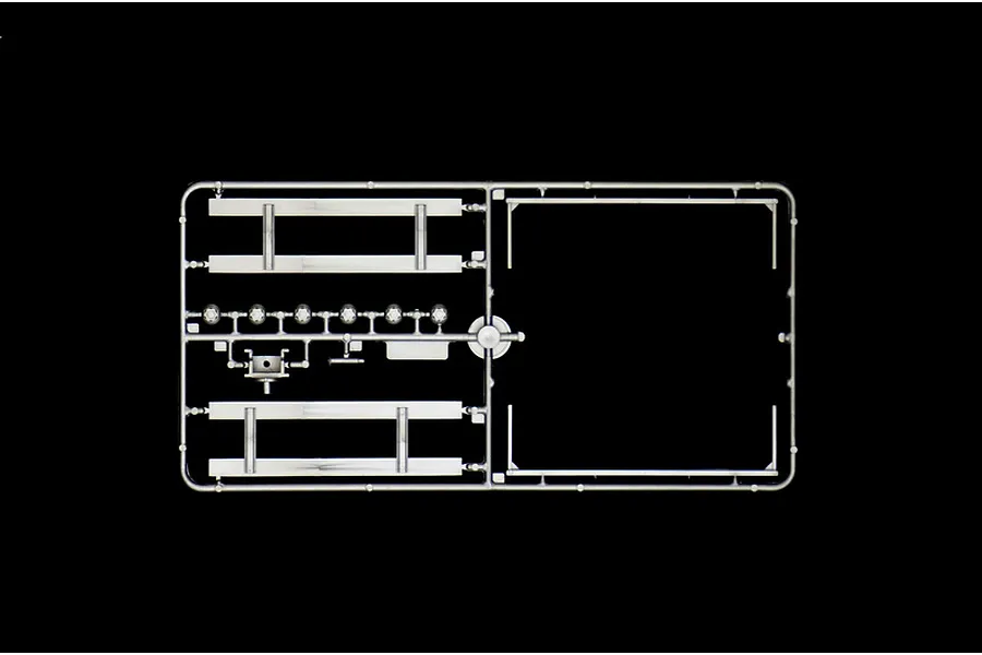A grey plastic sprue containing various model truck parts against a black background.