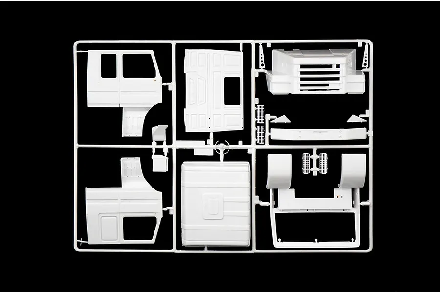 A white plastic model kit sprue containing various truck cab body panels and parts for an Italeri 1/24 scale Scania truck model.