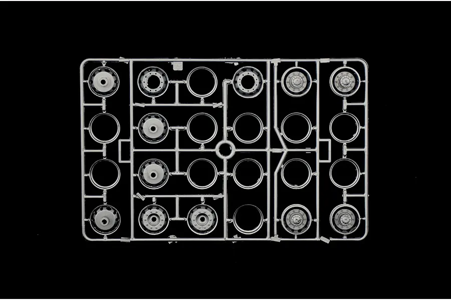 A grey plastic sprue containing various truck wheel rims for a 1/24 scale model kit, viewed from above against a black background.