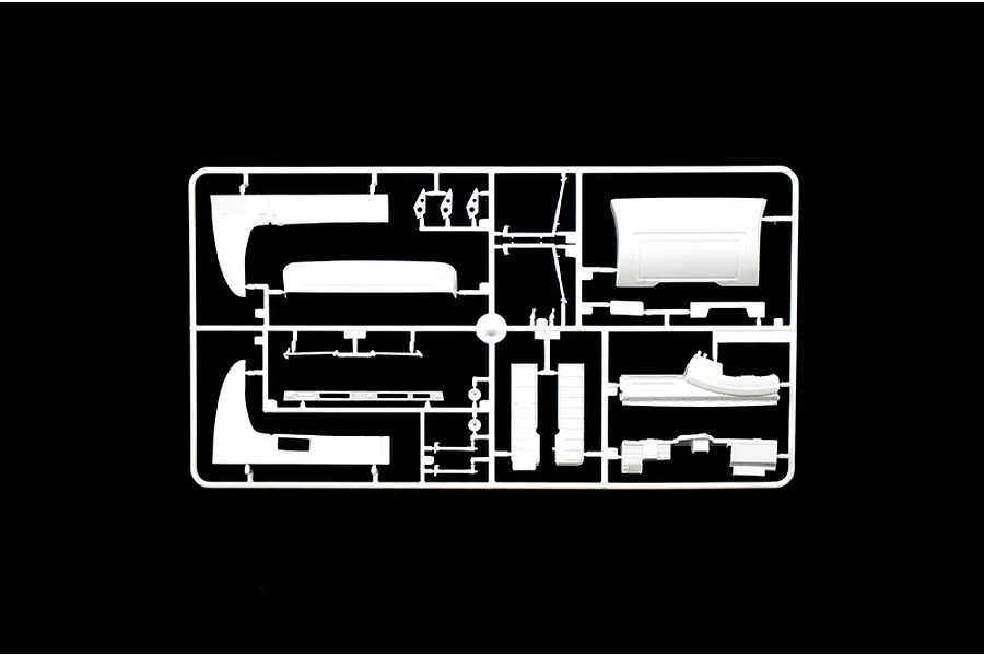 A white plastic model kit sprue containing various truck body parts on a black background.