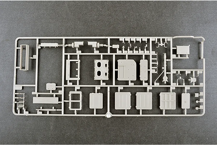 A grey plastic model kit sprue containing various flat panels, hatches, and small structural components for a 1/35 scale military vehicle model.