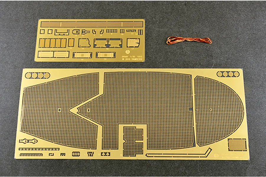 Two photo-etched brass sheets and a small length of copper wire for a 1/35 scale model kit, displayed on a dark grey surface.