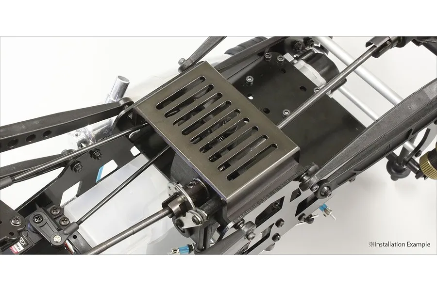 A close-up view of a Kyosho gunmetal aluminium lower guard installed on an RC car chassis, showing the slotted metal plate mounted between the frame rails.