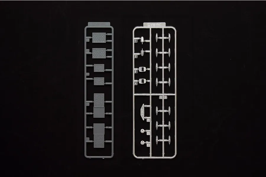 Two plastic model kit sprues for a 1/32 scale truck accessory set, featuring various small parts on a black background.