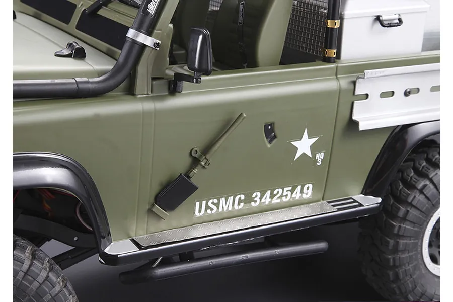 Side view of a 1/10 scale RC truck body in olive green with a mounted shovel tool, USMC markings, and silver side step detail.