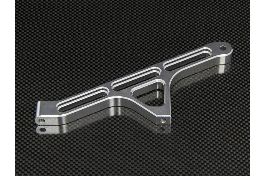 A silver aluminium rear chassis brace for an RC car, featuring a machined skeletonized design, shown against a black carbon fiber background.