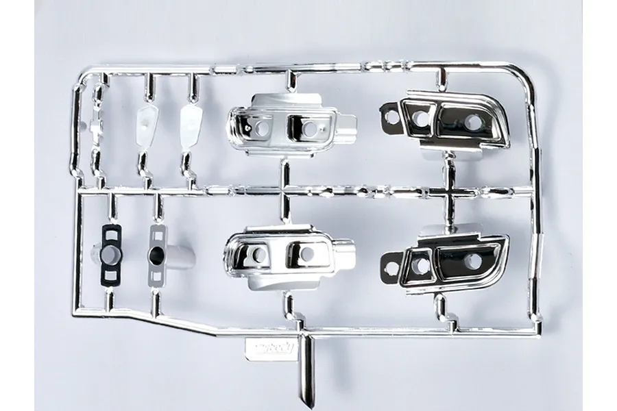A chrome-plated plastic parts tree containing light buckets for a 1/10 scale RC car body, set against a plain white background.