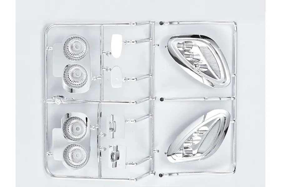 A chrome-plated plastic sprue containing various light bucket components for a 1/7 scale RC car model.