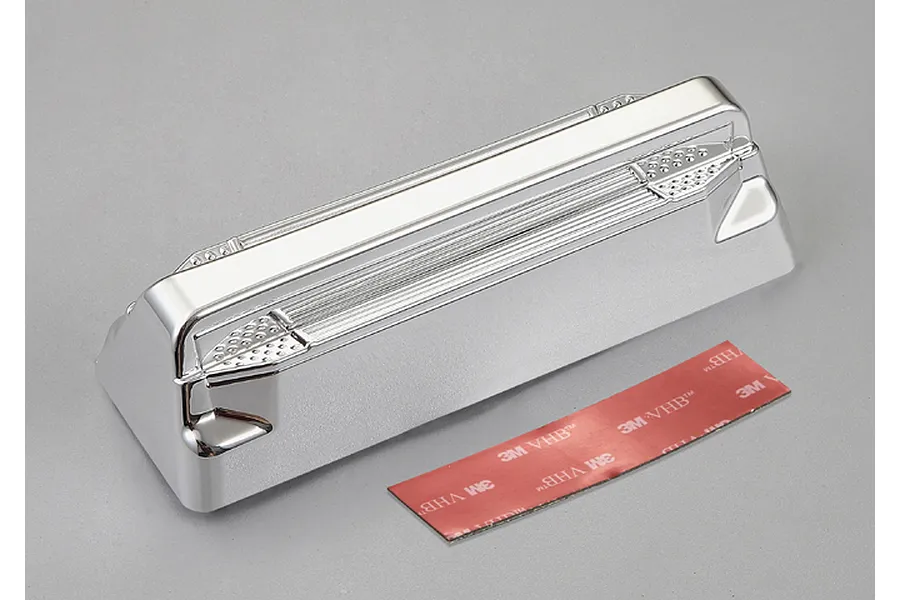 A chrome-plated RC truck pedal accessory by Killerbody, shown with a strip of 3M double-sided adhesive tape on a grey background.