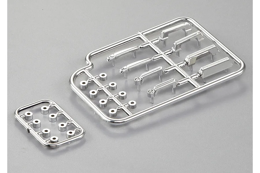 A set of chrome-plated plastic RC car door handles and small mounting components on two sprues against a grey background.