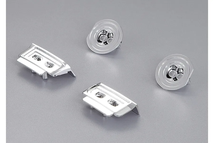 Four chrome-plated plastic light buckets for a 1/10 scale RC car, including two rectangular and two circular units on a grey background.
