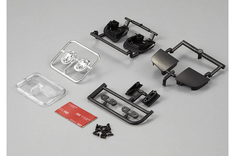 Killerbody 1/10 scale touring car moveable headlight kit components including plastic parts trees, clear lenses, screws, and 3M adhesive tape.