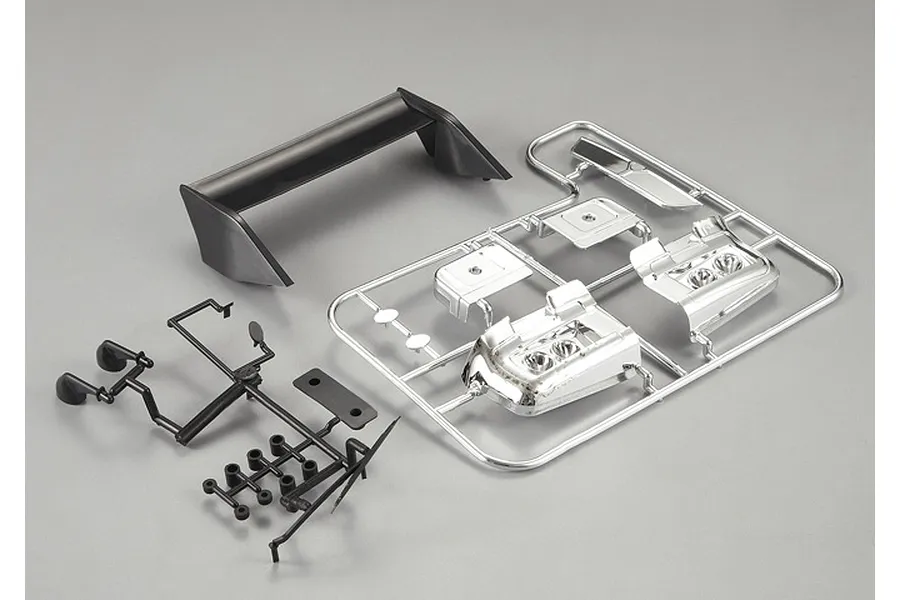 Killerbody 1/10 scale Lancia Beta Montecarlo plastic parts set including a black rear wing, black side mirrors, and a chrome-plated light bucket tree.