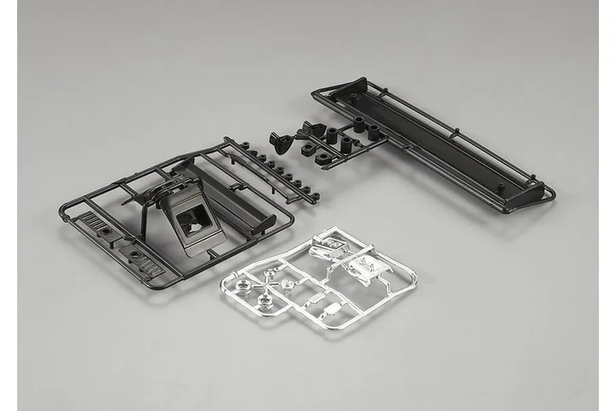 Killerbody Lancia LC2 plastic parts set on sprues, including black and chrome-plated components for RC car assembly.