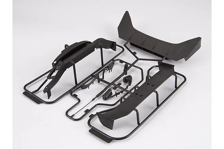 Black plastic parts tree for a 1/10 scale RC car, including a rear wing and bumper components, on a white background.