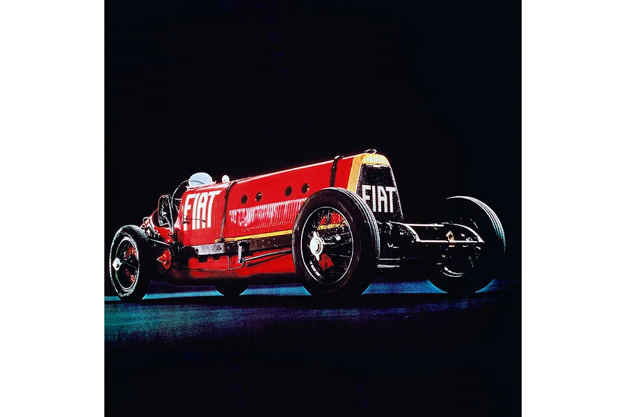 A side-angle view of the vintage red Fiat Mephistofele race car against a solid black background.