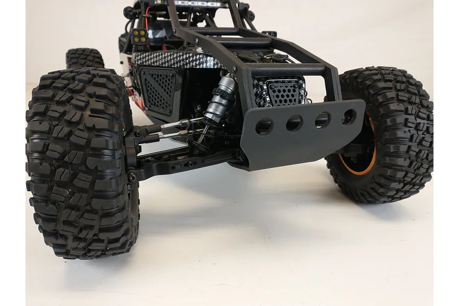 A T-Bone Racing front bumper installed on a 1/10 scale Losi Lasernut RC rock racer, viewed from a low front angle.