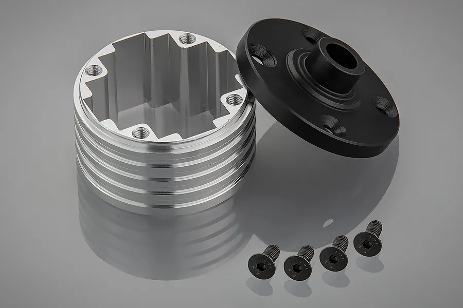 A silver aluminium differential housing with a black end cap and four small black screws on a grey reflective surface.