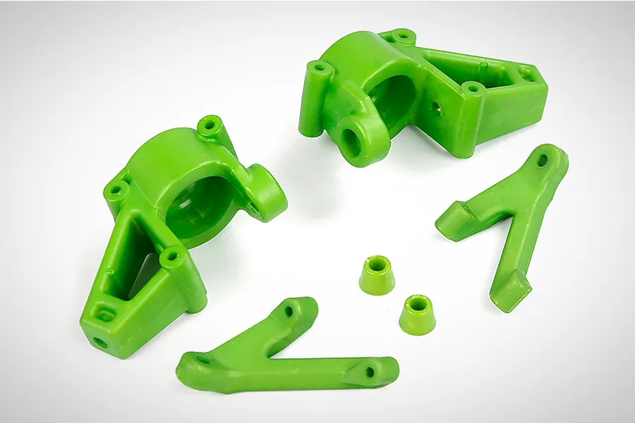 A set of bright green Rovan nylon front steering hub components and associated parts on a white background.