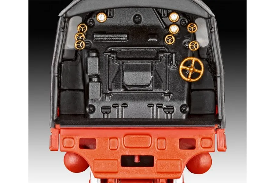 Close-up view of the detailed cab interior of a Revell 1/87 scale steam locomotive model kit, showing black control panel with gold-painted dials and wheels.